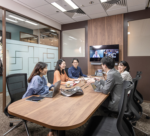 Members meading in a conference room with monitors.